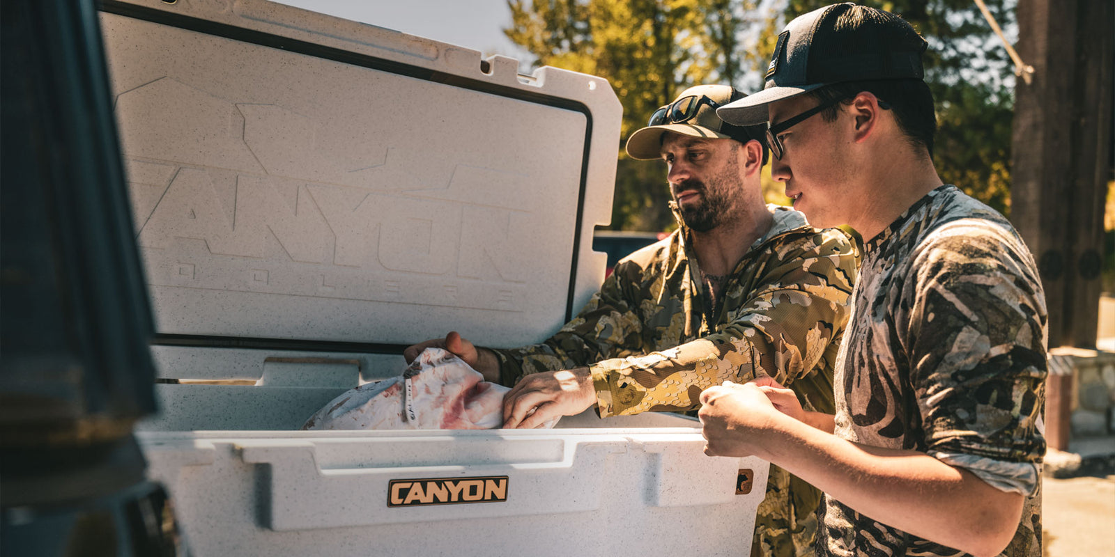 Hunters reaching into a White Marble Pro Series Cooler
