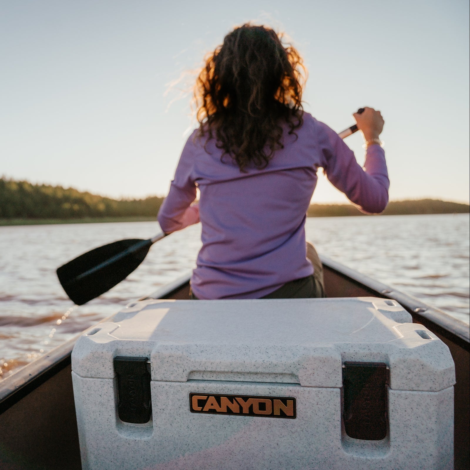 Woman paddling in a canoe with the Outfitter 35 V2 in White Marble