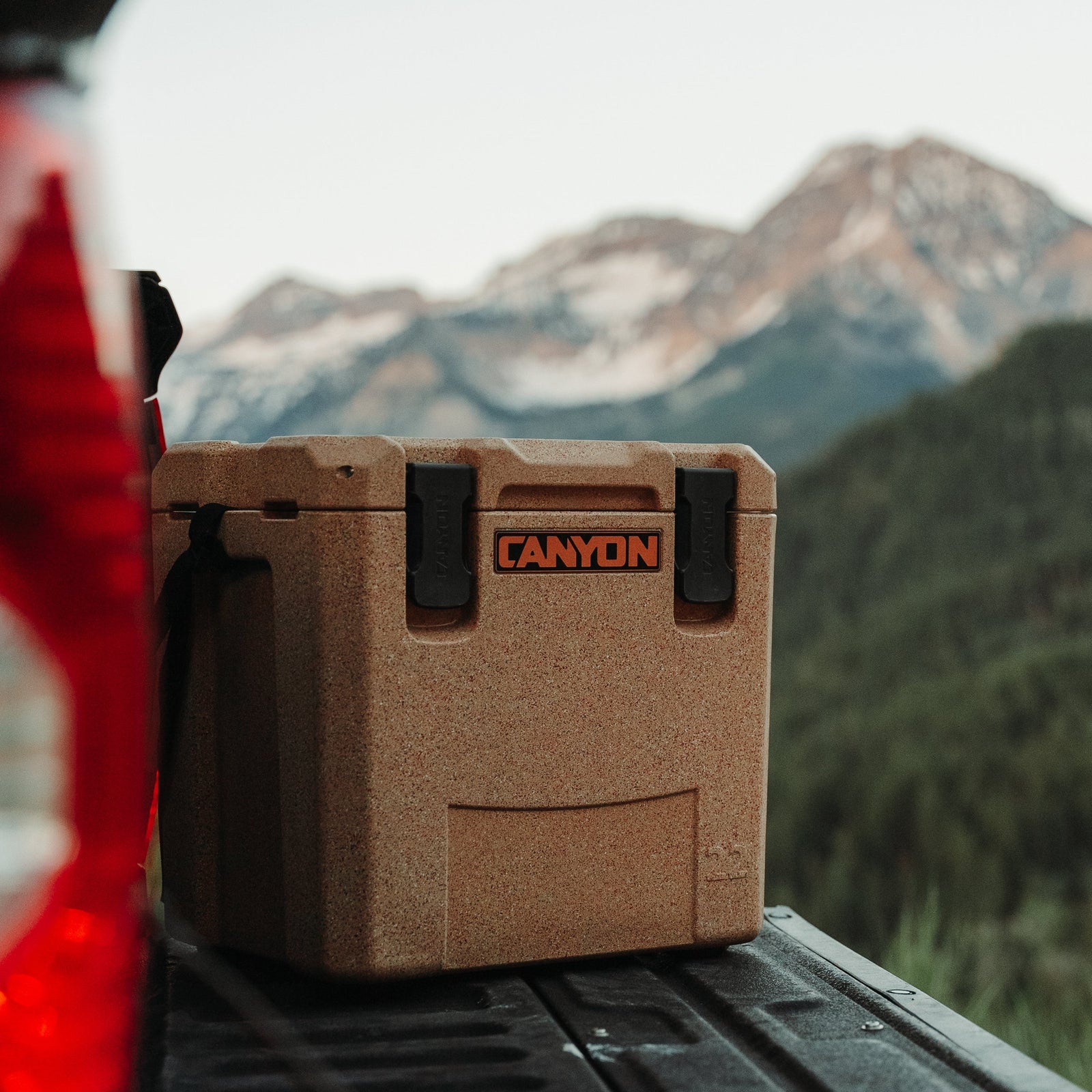 Outfitter 22 V2 in Sandstone on a truck bed in front of mountains