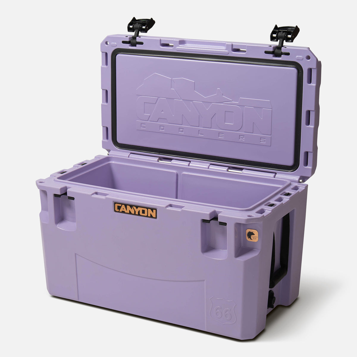 purple 66qt large rotomolded hard cooler offset lid open with black large handle latches and the &#39;canyon&#39; brand logo on the front. one strap handle visible, divider table visible in divider slot