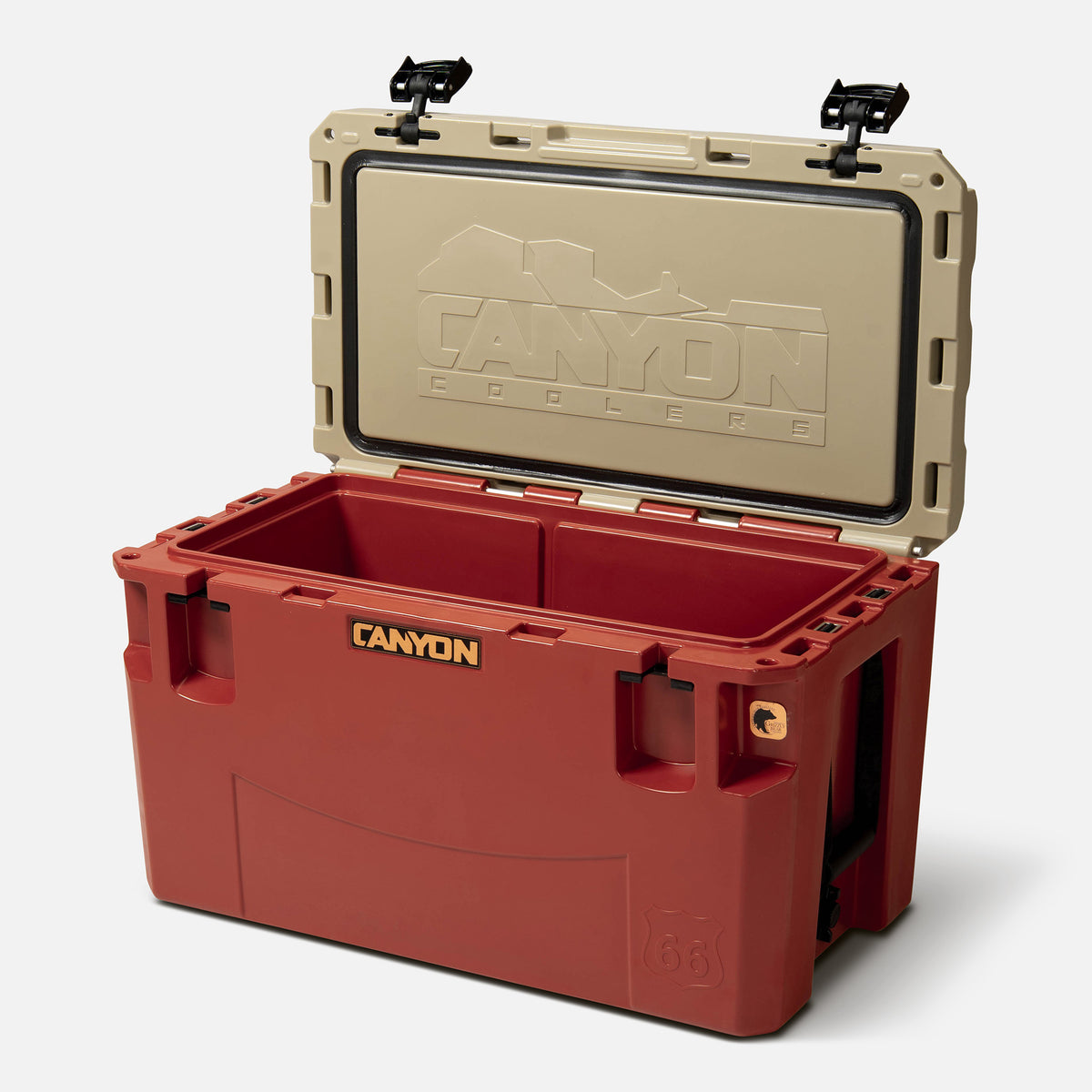 red with a tan lid 66qt large rotomolded hard cooler offset lid open with black large handle latches and the &#39;canyon&#39; brand logo on the front. one strap handle visible, divider table visible in divider slot