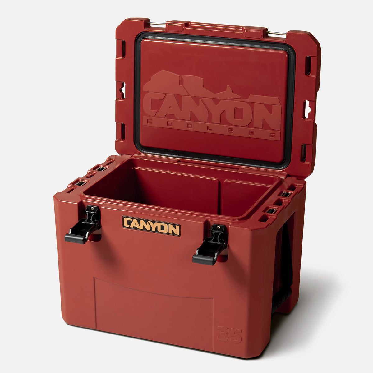 red 35qt medium rotomolded hard cooler offset lid open with black latches and the &#39;canyon&#39; brand logo on the front. strap handle 